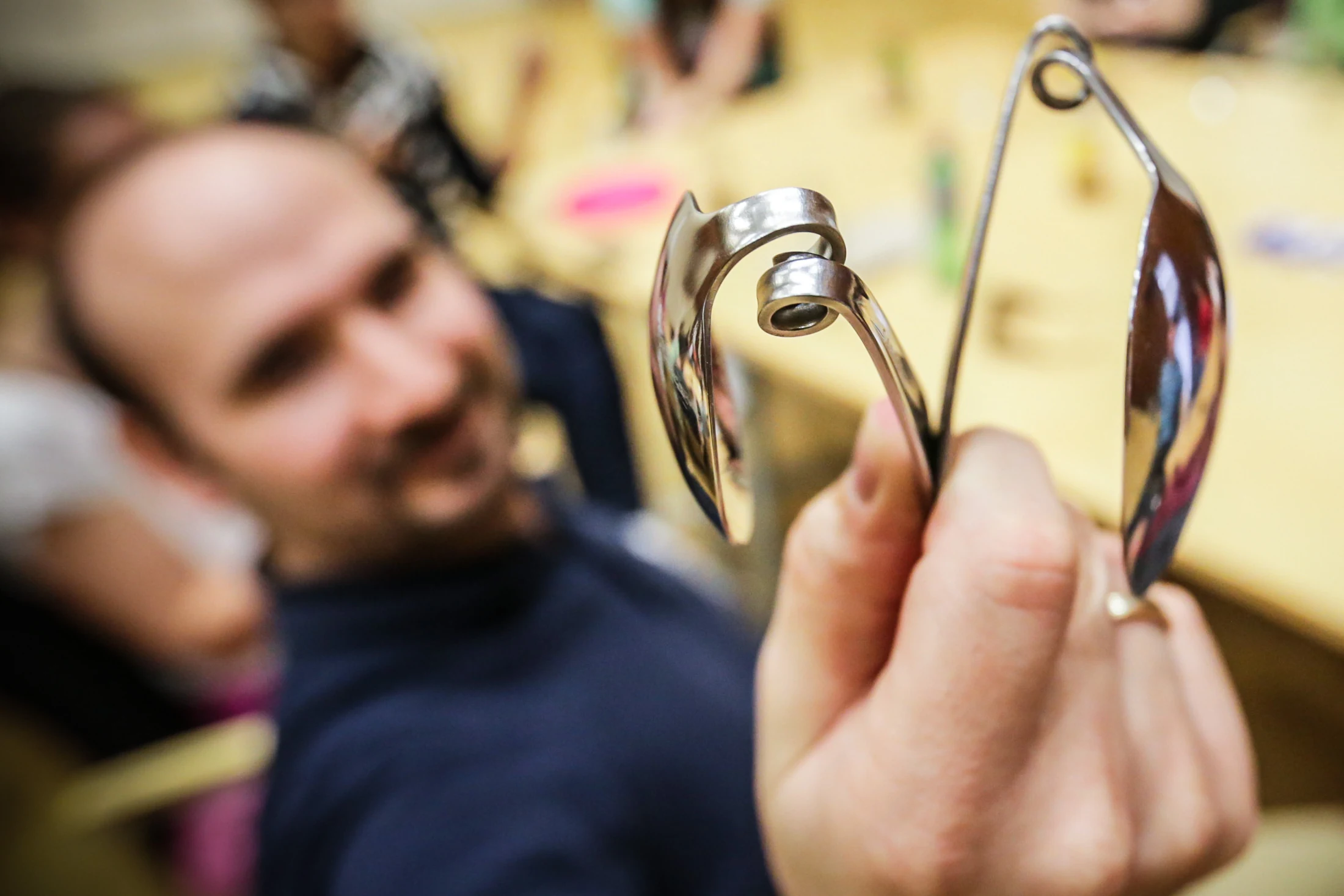Regular metal spoons shaped into intricate curves during a spoon-bending exercise