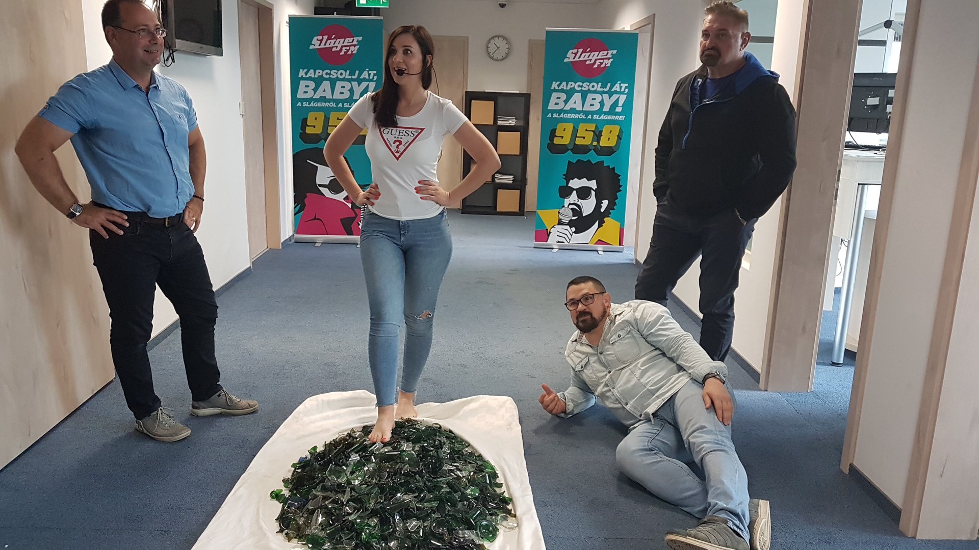 A charity supporter completing a supervised glass walk at Sláger FM