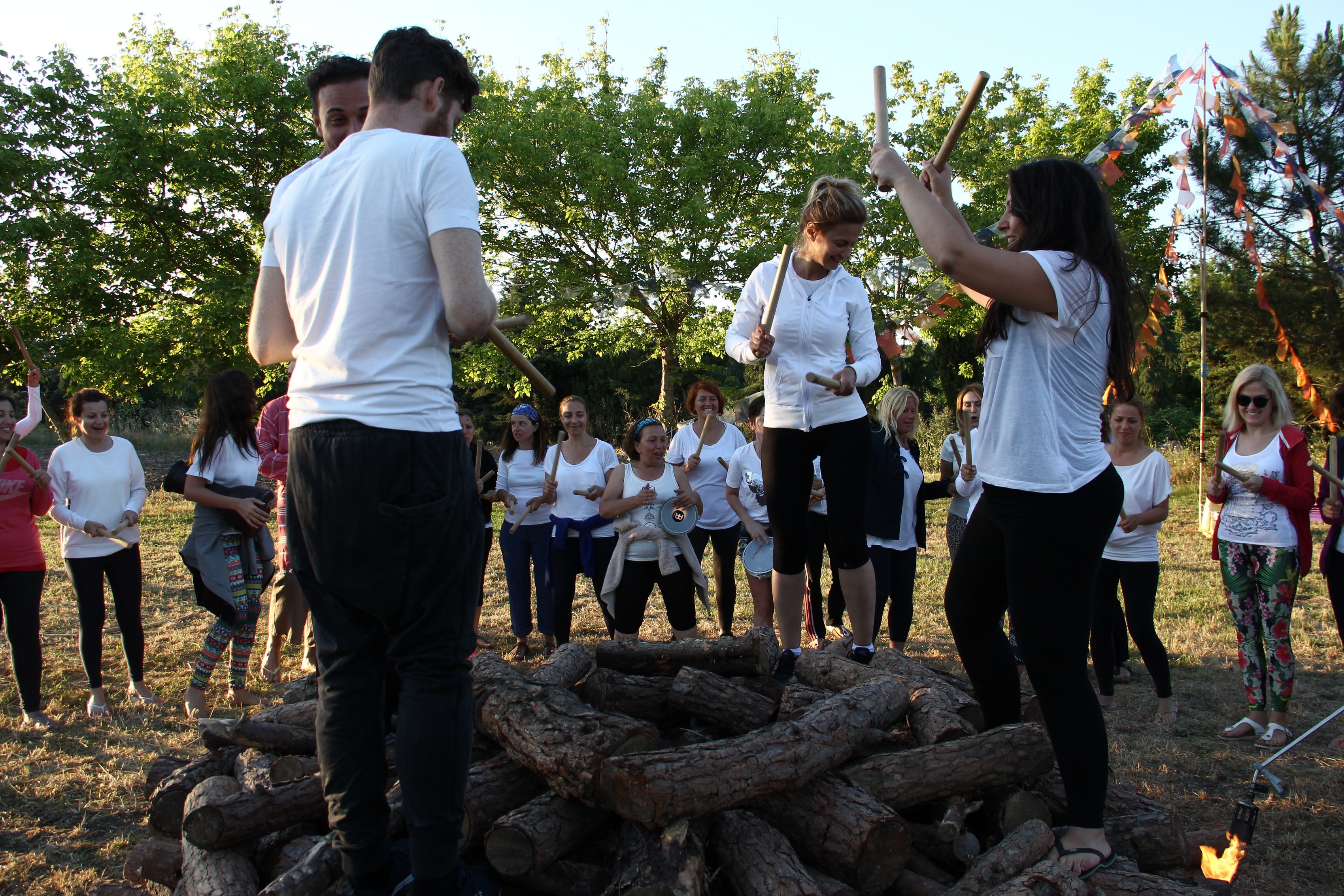 Participants preparing together around the unlit fire structure