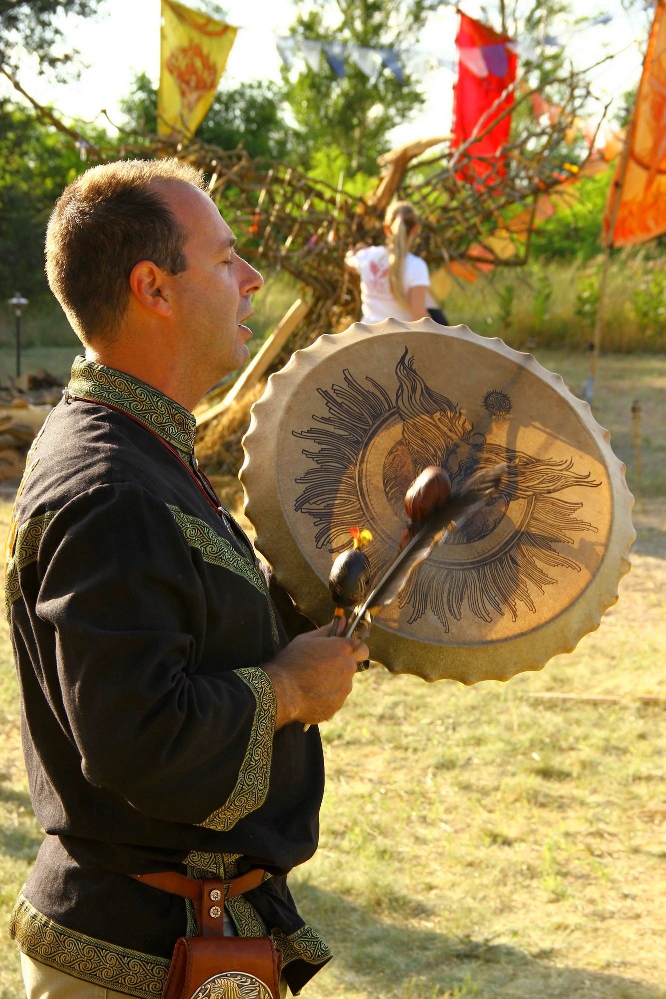 A firewalking facilitator leading the group with a ceremonial drum