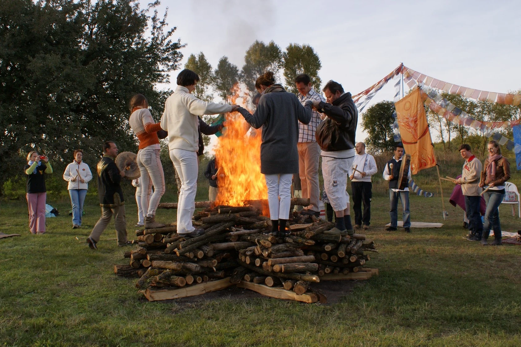 People holding hands while standing together on an autumn pyre