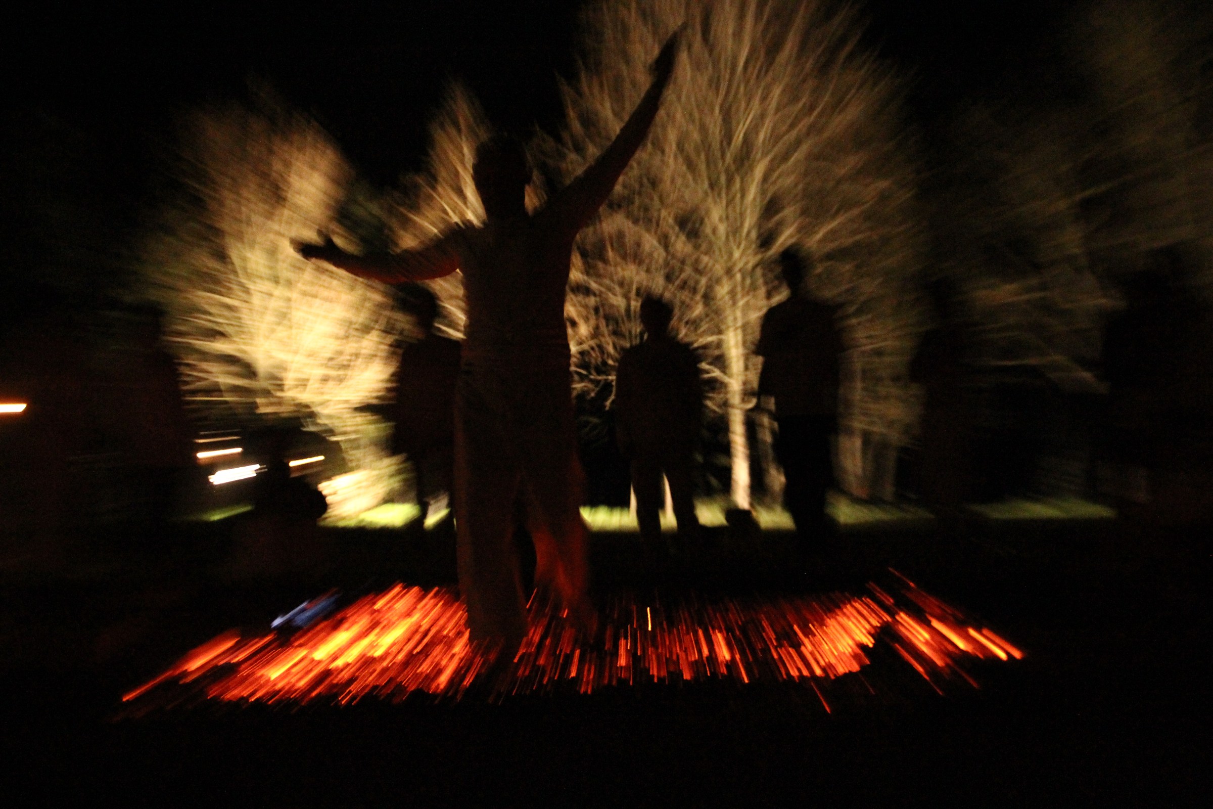 A participant crossing glowing embers during a night firewalk