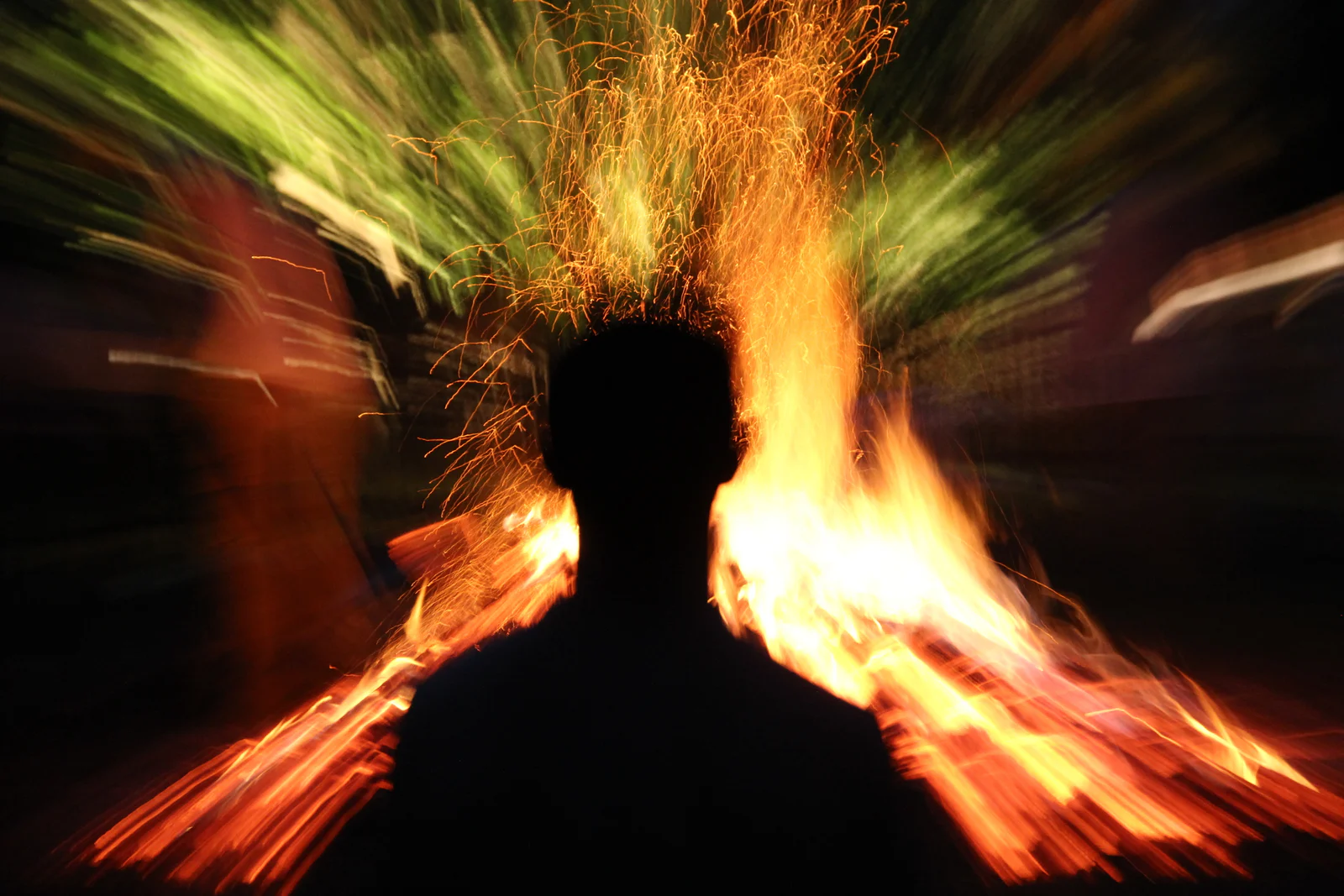 Participant standing before flying sparks and flames