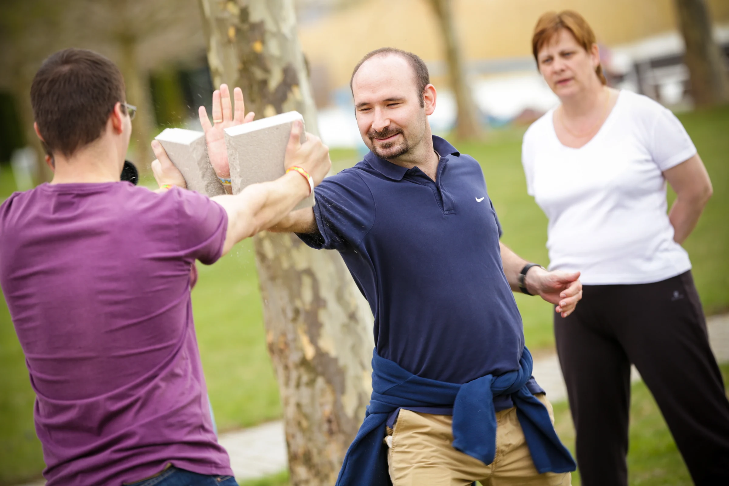 A participant breaking a concrete block during a development exercise