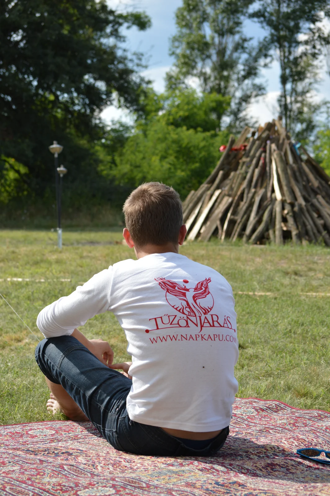 A participant considering a path beside a prepared fire structure