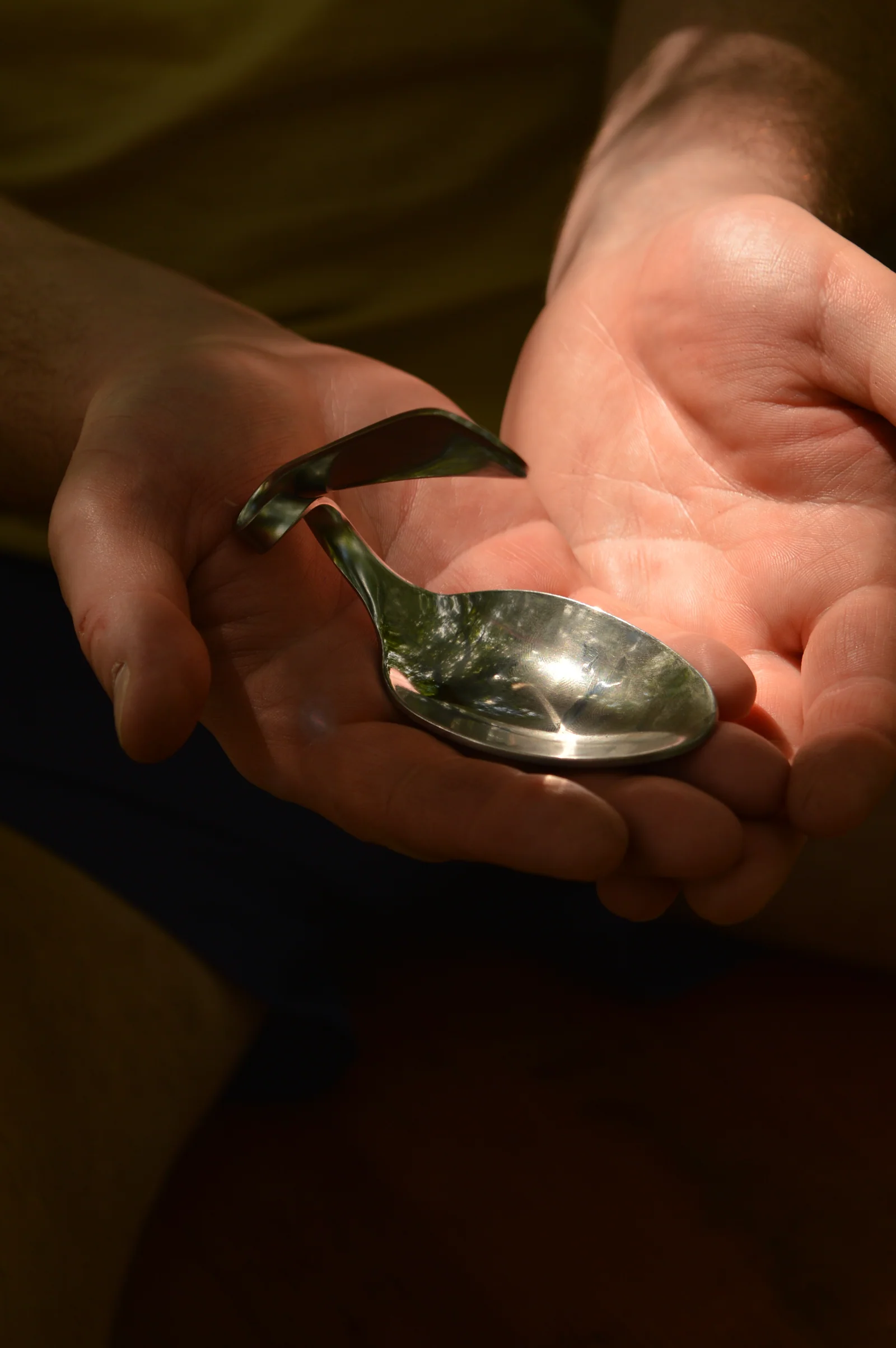 A carefully reshaped spoon resting in open hands