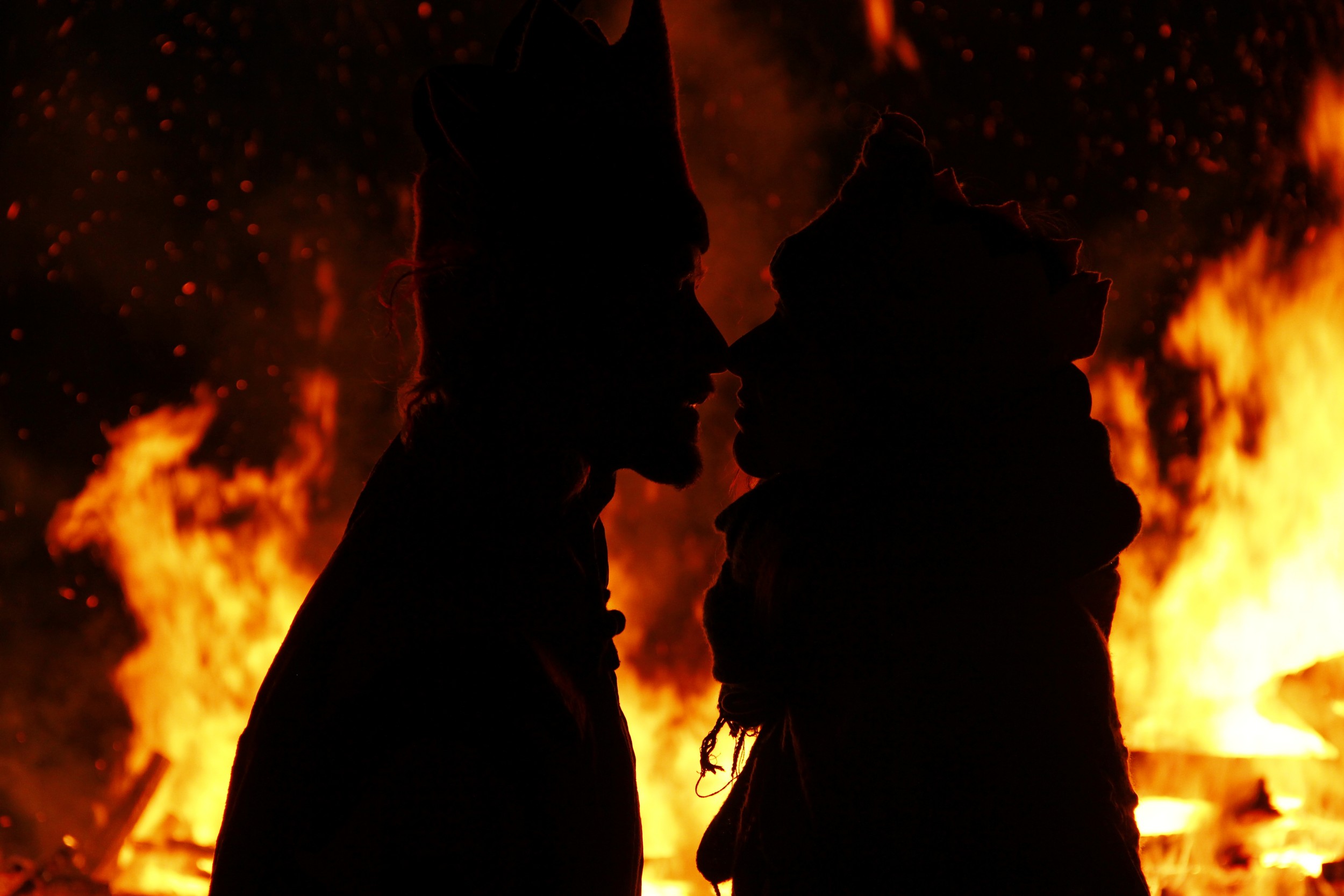 A couple sharing a quiet moment in silhouette before the fire
