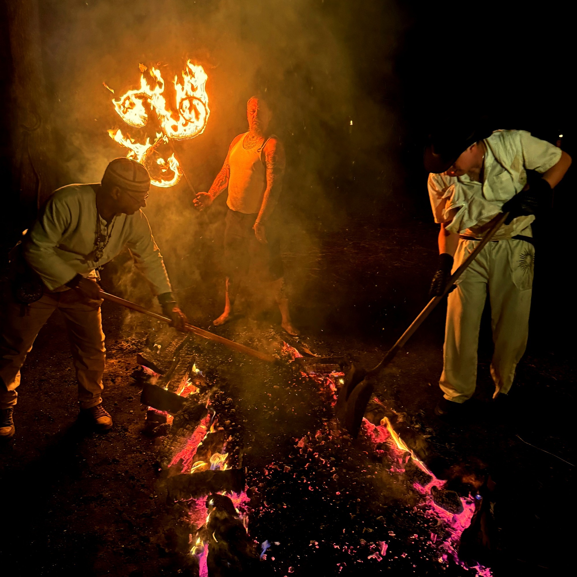 Firekeepers tending an ember bed during an advanced ceremony