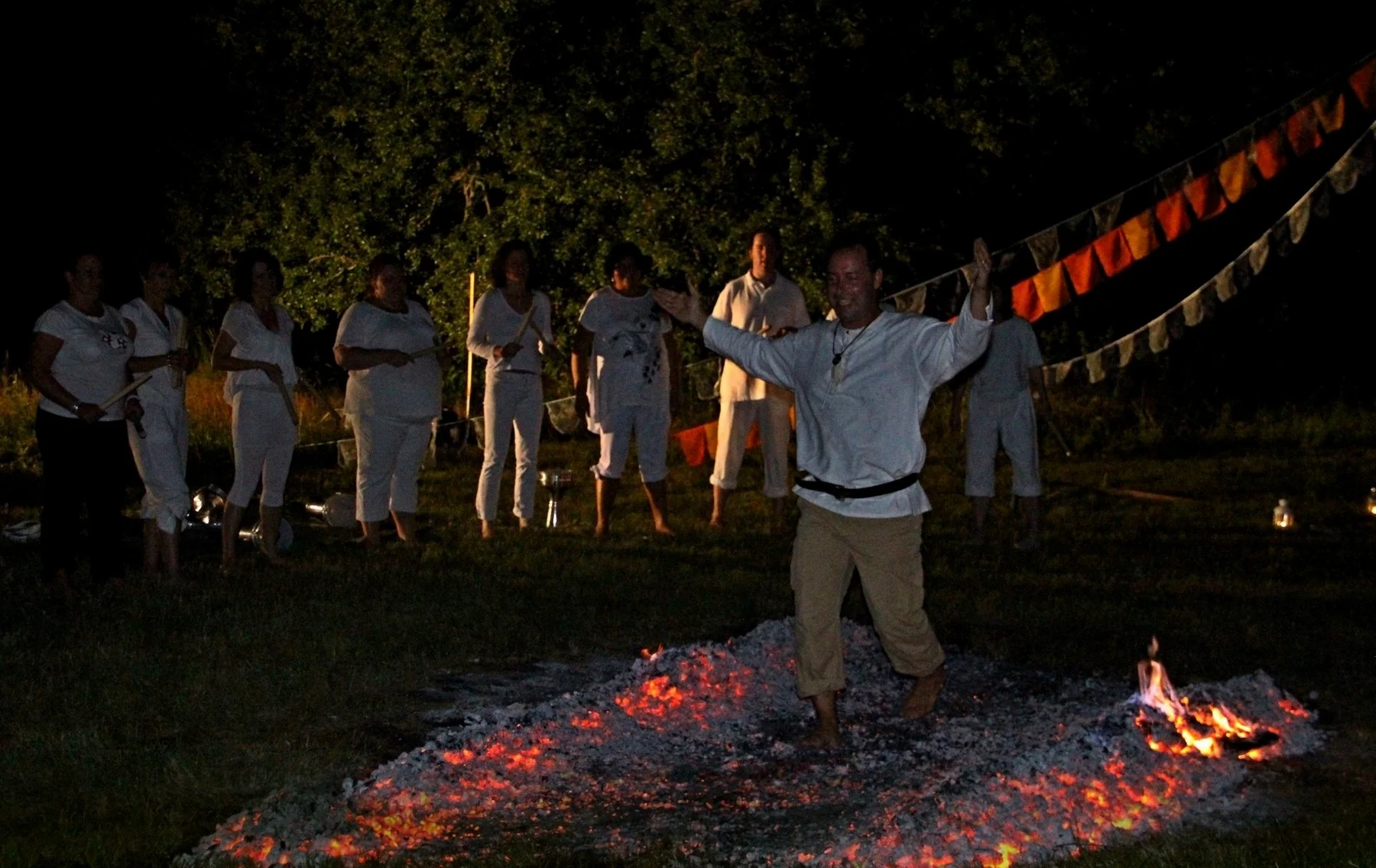 A participant crossing glowing embers with open posture