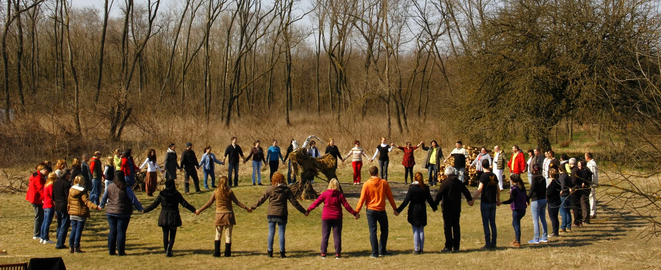 Participants forming a wide circle during outdoor group preparation