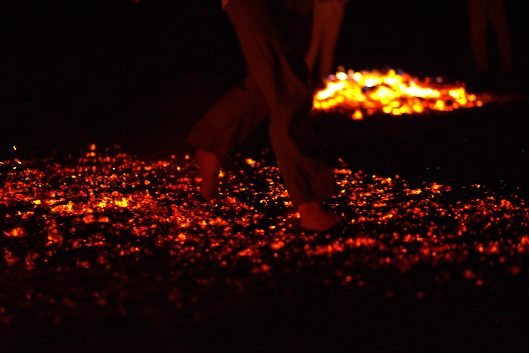 Bare feet crossing a professionally prepared bed of glowing embers